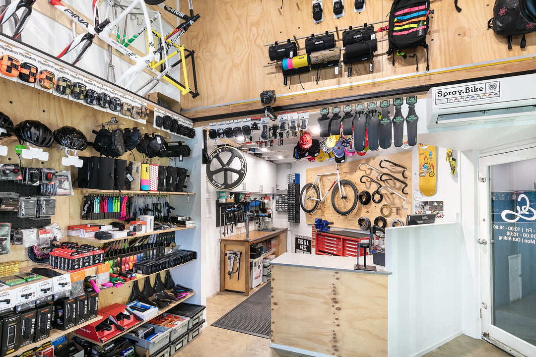 The original front counter and workshop of GEAR Shop Brisbane at their old address in 3a Browning St, West End. It features many parts, and accessories mounted on the walls, along with art, post cards, and race mementos